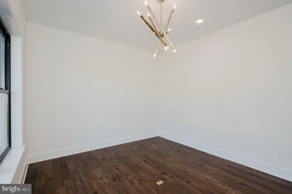 an empty room with wooden floor and a fireplace