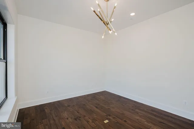 an empty room with wooden floor and a fireplace