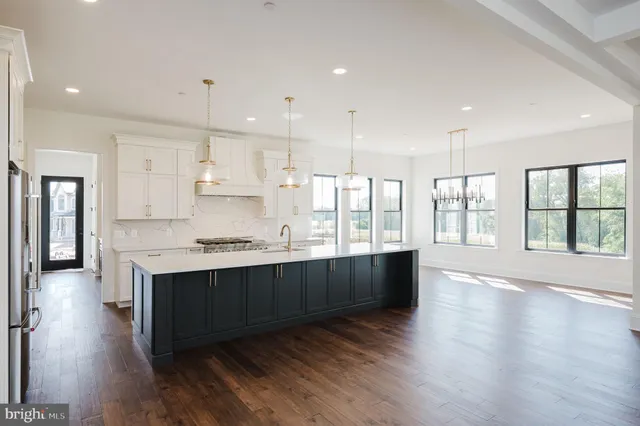 a kitchen with stainless steel appliances a sink a stove a refrigerator and cabinets
