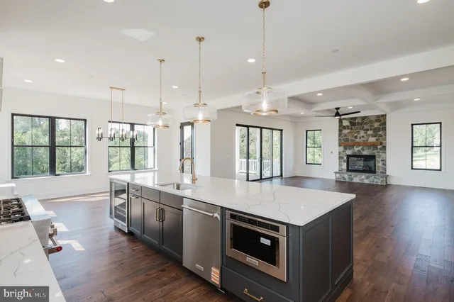 a kitchen with stainless steel appliances granite countertop a sink a stove and a wooden floors