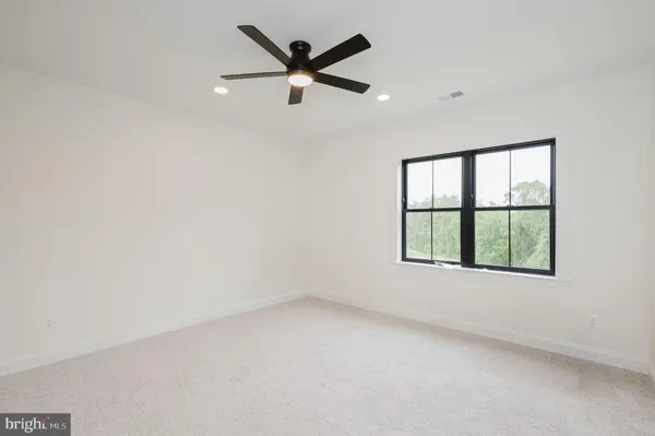 an empty room with closet and a chandelier fan
