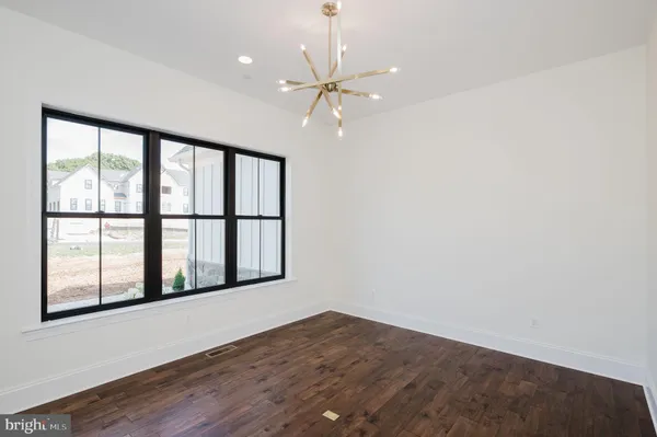 an empty room with wooden floor and ceiling fan