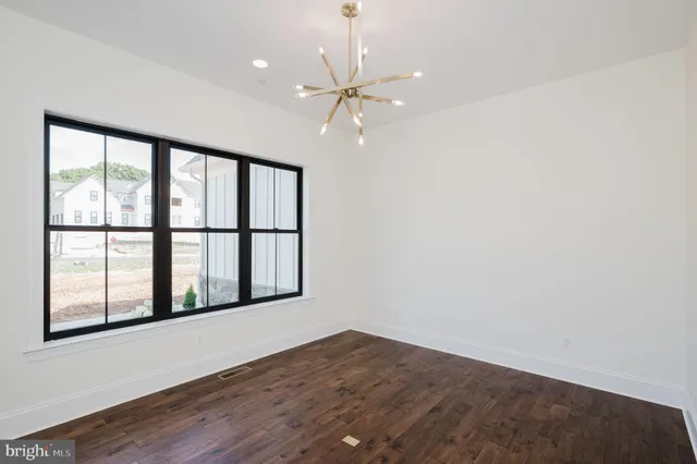 an empty room with wooden floor and ceiling fan