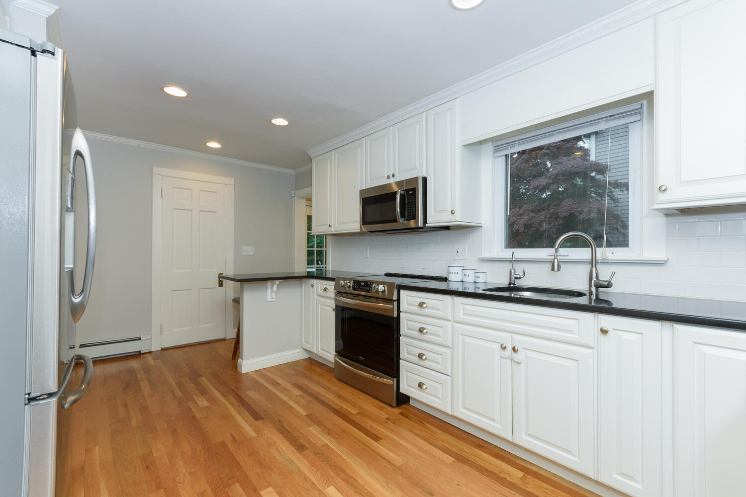 18 Patton Drive Darien, CT 06820 - Photo 10 of 35 a kitchen with granite countertop white cabinets and black stainless steel appliances
