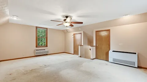 an empty room with windows and fan