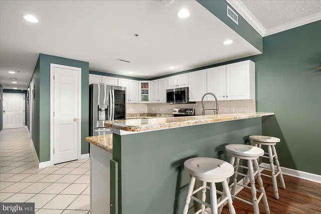 a kitchen with granite countertop a refrigerator and a sink