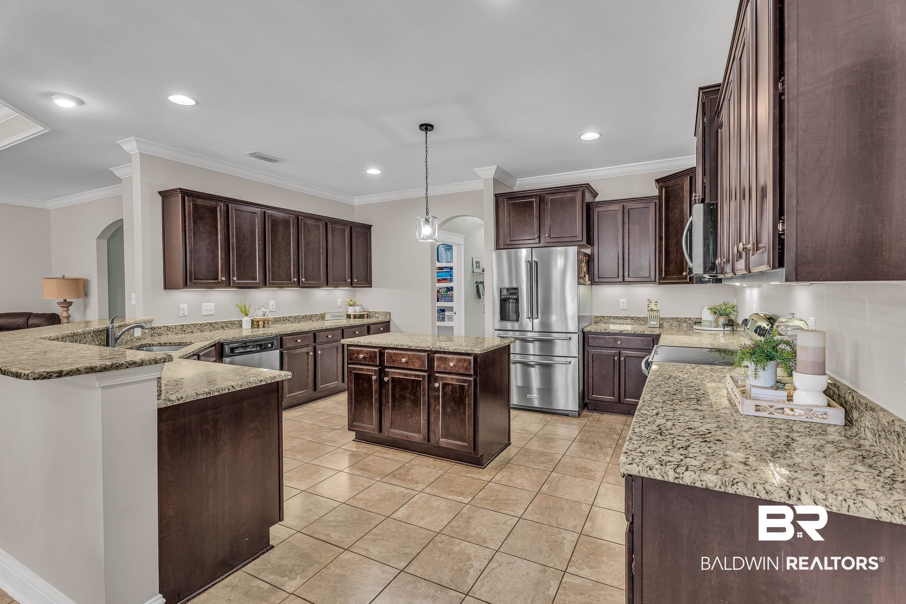 9675 Camberwell Drive Daphne, AL 36526 - Photo 11 of 34 Kitchen with appliances with stainless steel finishes, arched walkways, dark brown cabinetry, crown molding, and recessed lighting