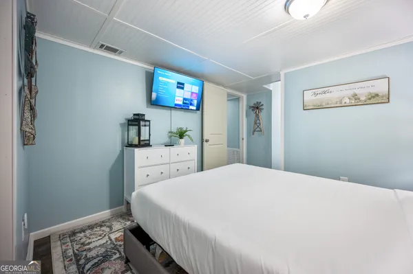 a bedroom with a bed and a flat screen tv