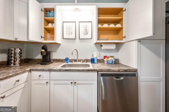 a kitchen with stainless steel appliances granite countertop a sink and a white cabinets