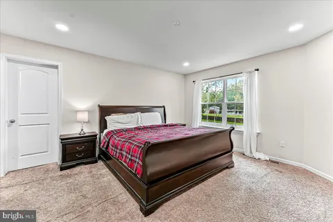 a bed sitting in a spacious bedroom next to a window