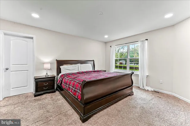 a bed sitting in a spacious bedroom next to a window