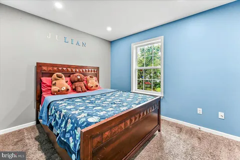 a bed sitting in a bedroom next to a window