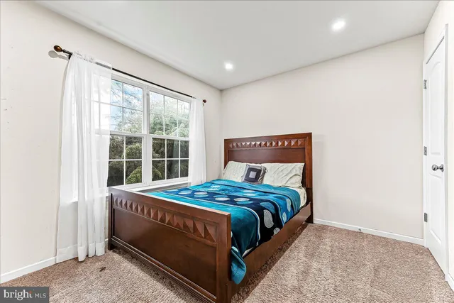 a bed sitting in a bedroom next to a window