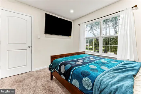 a bedroom with a bed and flat screen tv