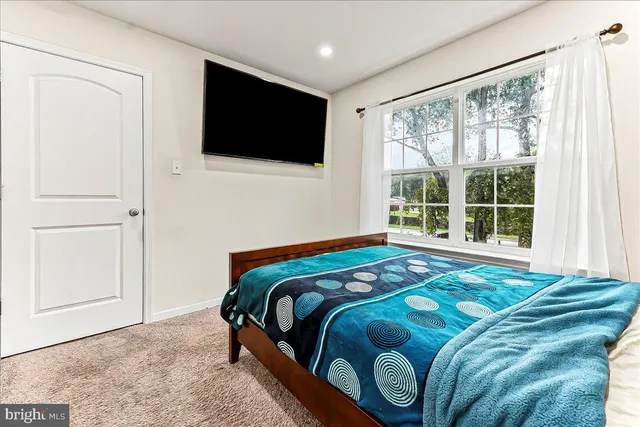a bedroom with a bed and flat screen tv
