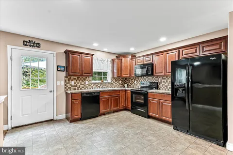 a kitchen with stainless steel appliances granite countertop a refrigerator and a stove top oven