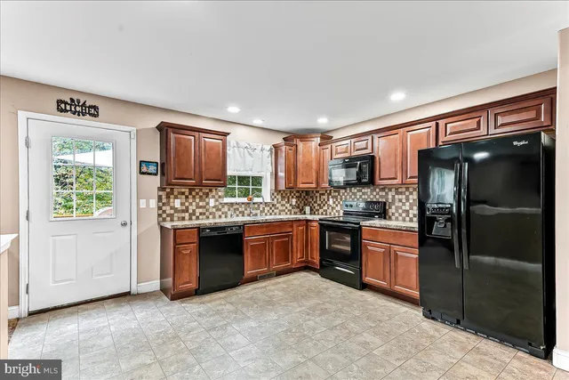a kitchen with stainless steel appliances granite countertop a refrigerator and a stove top oven