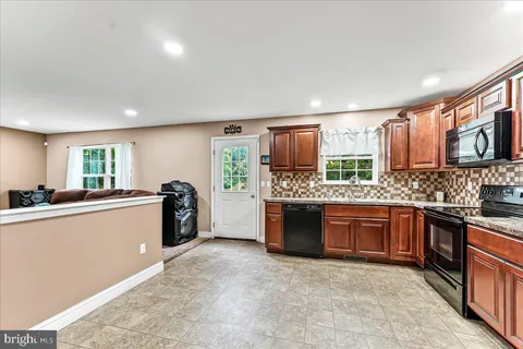 a large kitchen with kitchen island granite countertop a stove sink and cabinets