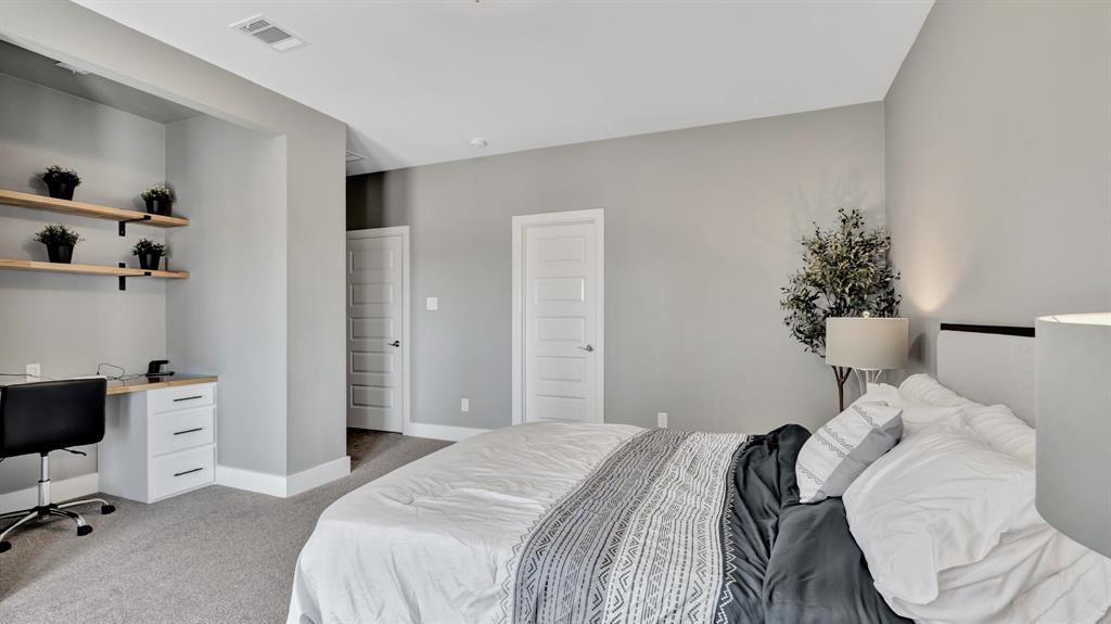 602 Winners Circle Rowlett, TX 75088 - Photo 23 of 35 Third level, secondary bedroom, with a dedicated desk area with built-in cabinetry and floating wood shelves