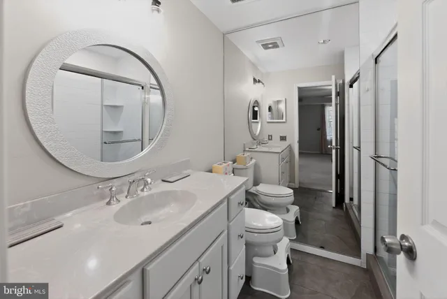 a bathroom with a sink toilet and shower a mirror
