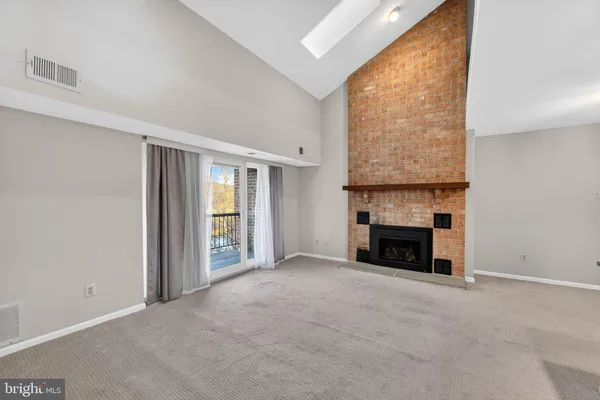 a view of empty room with a fireplace and window