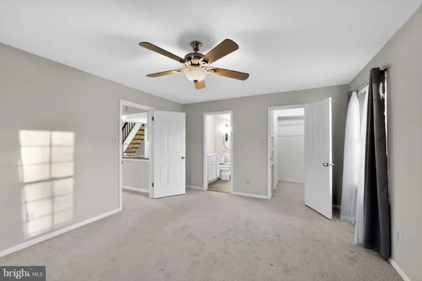 a view of empty room with windows and ceiling fan