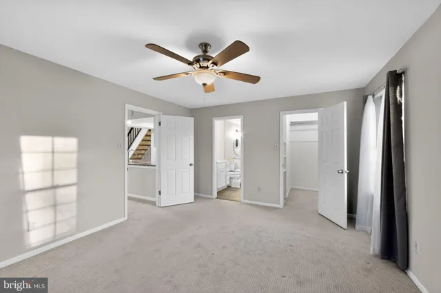 a view of empty room with windows and ceiling fan
