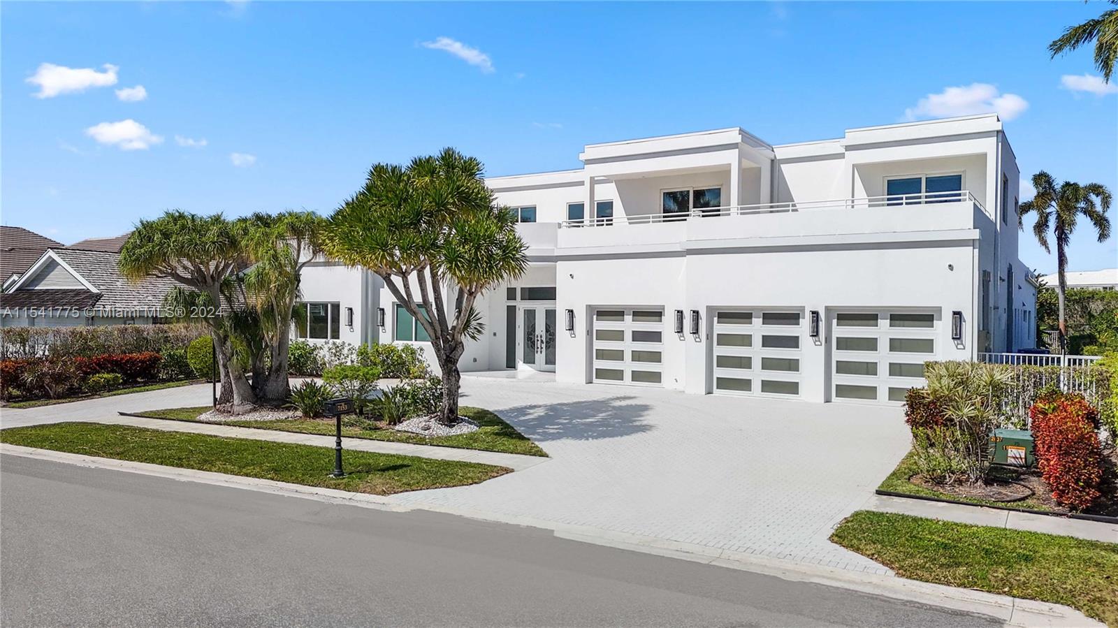 7153 Valencia Drive Boca Raton, FL 33433 - Photo 2 of 80 a front view of a house with a yard and trees