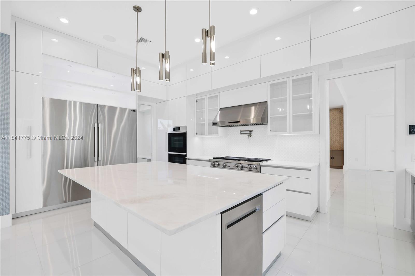 7153 Valencia Drive Boca Raton, FL 33433 - Photo 6 of 80 a large kitchen with kitchen island a stove a sink a refrigerator and white cabinets