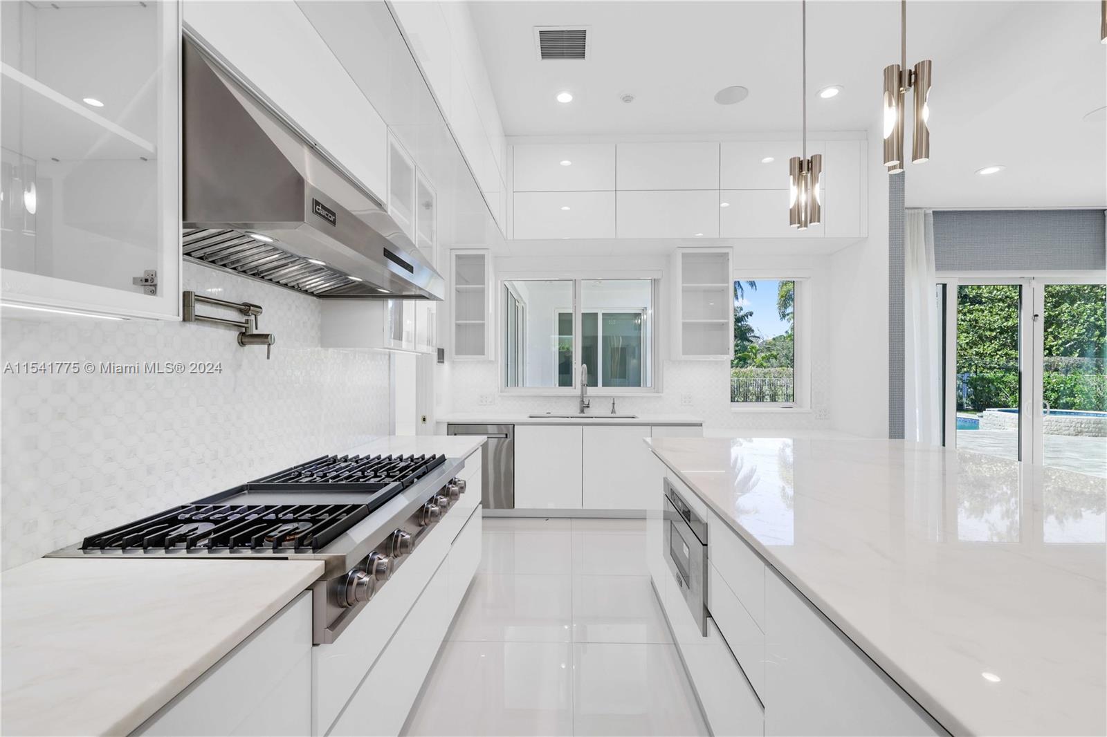 7153 Valencia Drive Boca Raton, FL 33433 - Photo 8 of 80 a kitchen with stainless steel appliances sink stove and cabinets