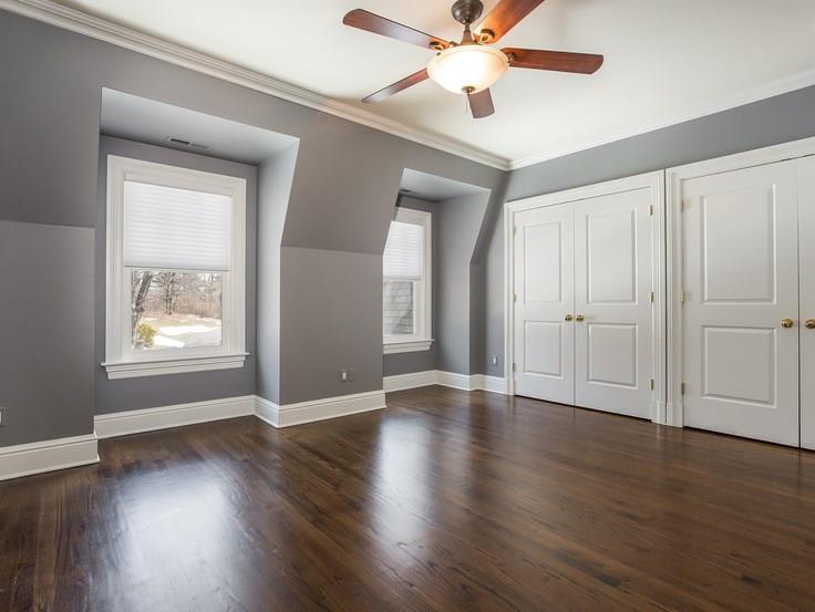 299 Ridgefield Road Wilton, CT 06897 - Photo 18 of 29 an empty room with wooden floor chandelier fan and windows