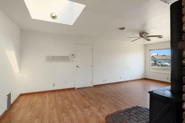 an empty room with a bench and a wooden floor