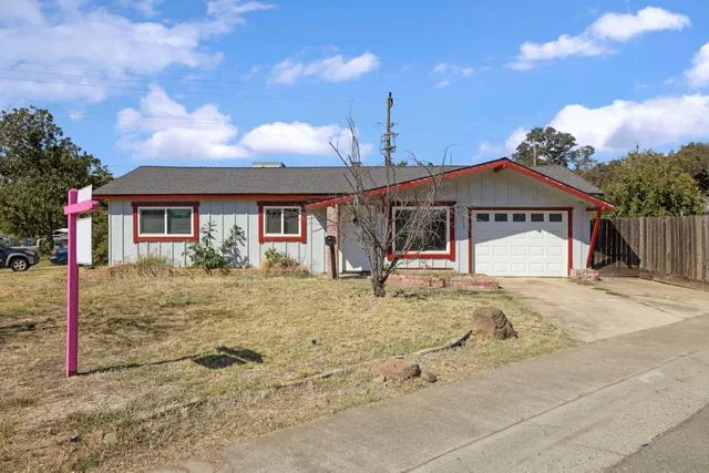 a view of a white house with a yard and large tree