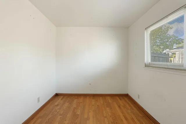a view of a small space with wooden floor and a window