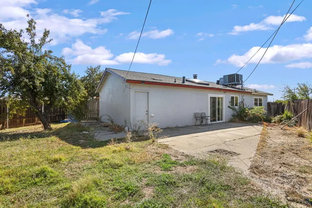 a backyard of a house with table and chairs