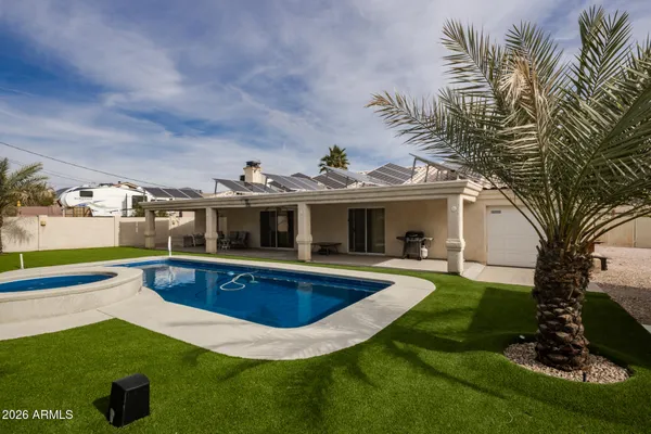 a view of a house with swimming pool and a yard