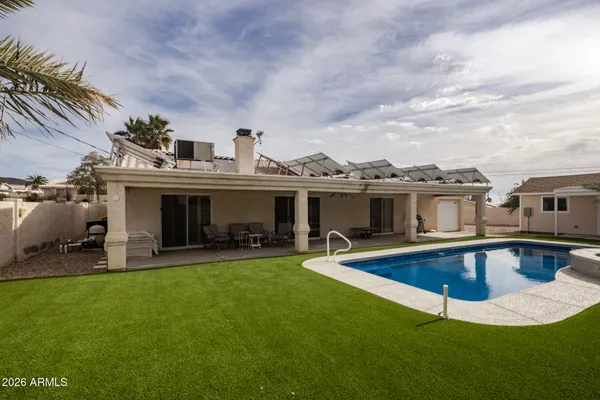 a view of a house with swimming pool and sitting area
