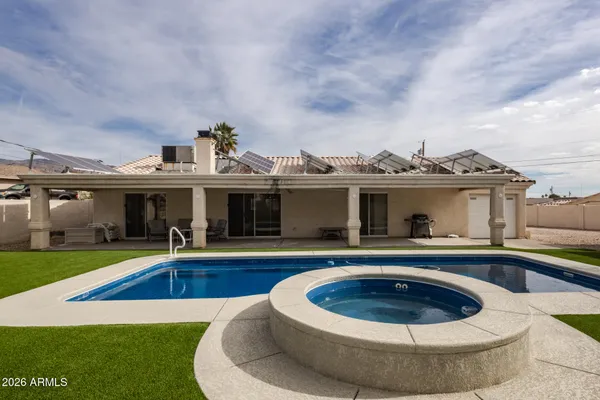 a view of a house with swimming pool and furniture