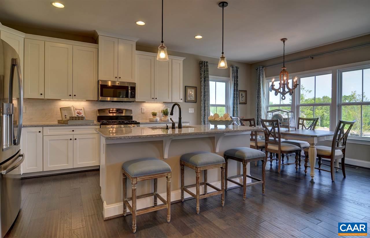 216 Ridgemont Road Ruckersville, VA 22968 - Photo 5 of 12 a kitchen with stainless steel appliances granite countertop a stove a sink a microwave a dining table and chairs with wooden floor
