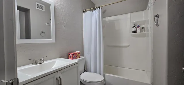 a bathroom with a sink vanity mirror and toilet