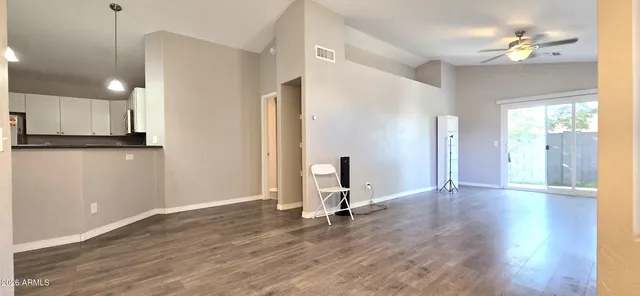 a view of a kitchen with wooden floor and a ceiling fan