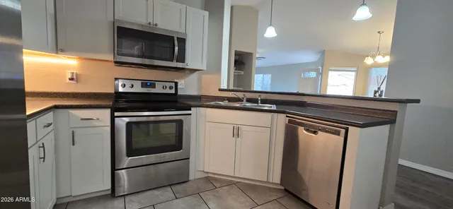 a kitchen with stainless steel appliances granite countertop a stove and a microwave
