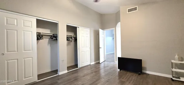 a view of a livingroom with wooden floor and a bathroom