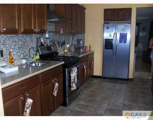 35 Windsor Road Edison, NJ 08817 - Photo 7 of 10 a kitchen with stainless steel appliances granite countertop a sink a stove and a refrigerator