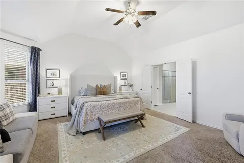 a spacious bedroom with a bed and a chandelier