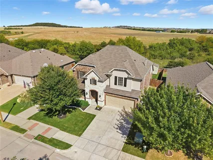 an aerial view of a house with a garden and lake view