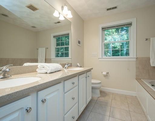 337 Springs Road Bedford, MA 01730 - Photo 19 of 30 a bathroom with a double vanity sink a large mirror and a toilet