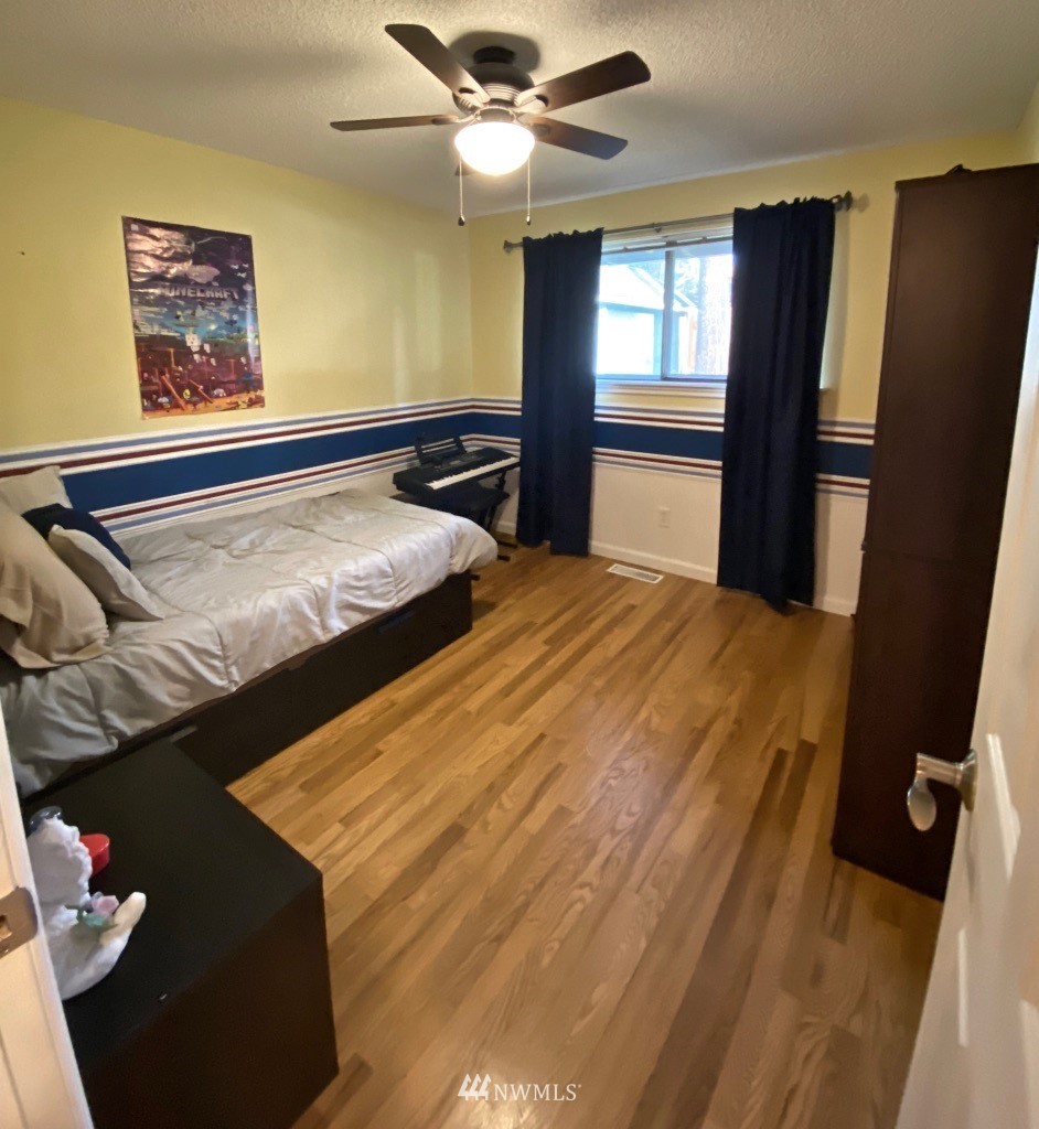 14530 166th Place Southeast Renton, WA 98059 - Photo 19 of 30 a bedroom with a bed and a chandelier