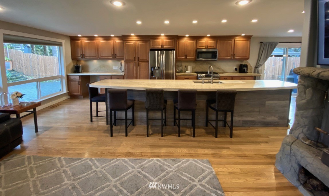14530 166th Place Southeast Renton, WA 98059 - Photo 4 of 30 a kitchen with kitchen island granite countertop a living room and a view of living room