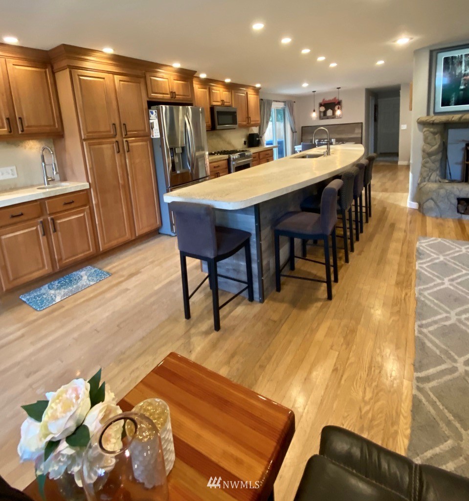 14530 166th Place Southeast Renton, WA 98059 - Photo 6 of 30 a dining room with stainless steel appliances kitchen island granite countertop a table chairs and a refrigerator